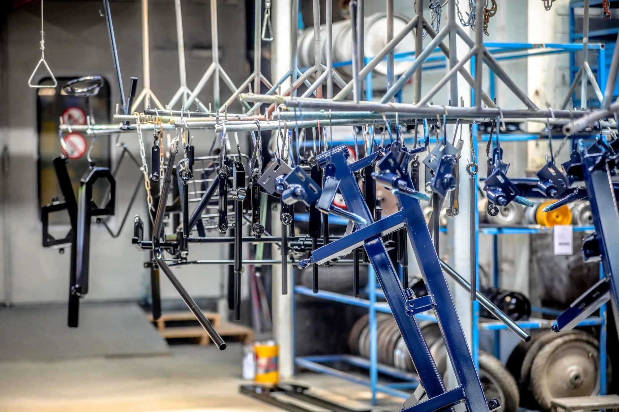 Pièces de châssis laquées suspendues à la ligne de peinture dans l’atelier de Qarts